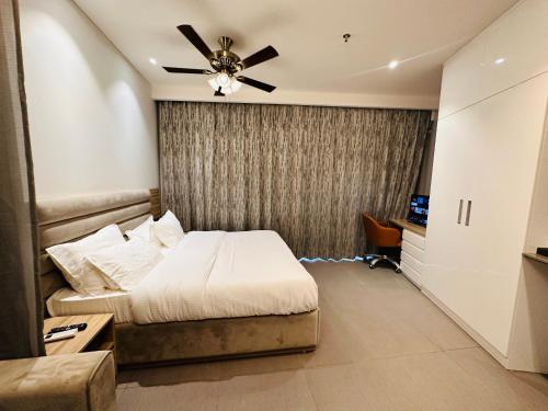 1 dormitorio con 1 cama y ventilador de techo en 21st Floor SkyStudio Suite with Balcony en Nueva Delhi