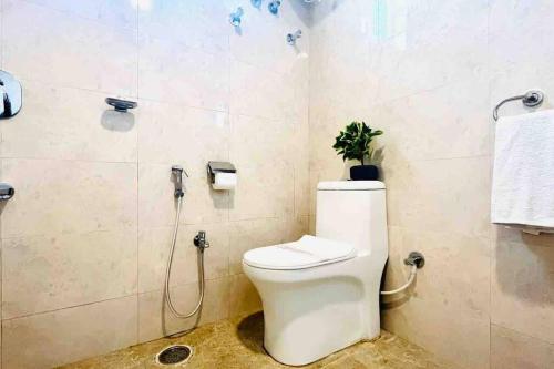 a bathroom with a toilet with a plant on the wall at BluO 1BHK Gachibowli - Terrace Garden, Lift in Hyderabad
