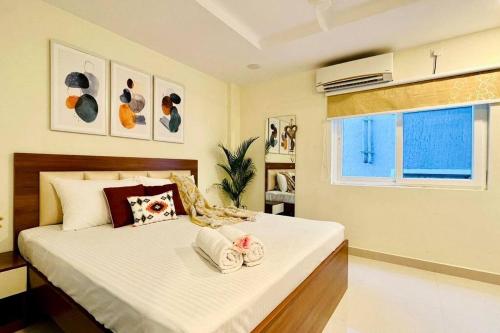 a bedroom with a large bed with towels on it at BluO 1BHK Gachibowli - Terrace Garden, Lift in Hyderabad