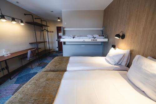 una camera d'albergo con 2 letti e una scrivania di Quality Hotel Royal Corner a Växjö