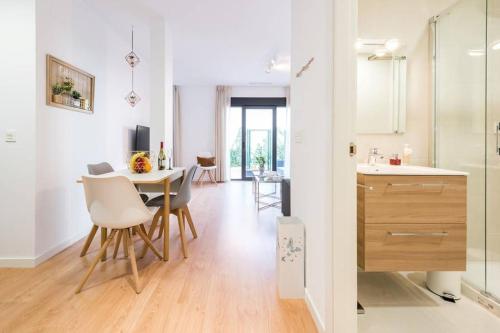 uma cozinha e sala de jantar com mesa e cadeiras em Apartamento con jardin privado y portero (B) em Madri