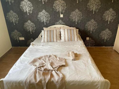 1 cama blanca en un dormitorio con pared en Stunning 1-Bed Apartment in Larnaca near the sea, en Perivolia