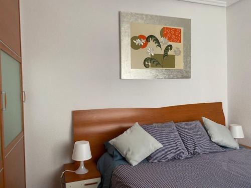 a bedroom with a bed and a picture on the wall at 80 m2 recién reformado, acogedor y elegante. in Balmaseda