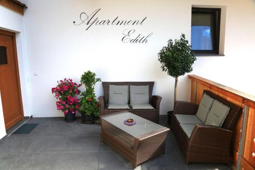 a patio with chairs and a table and a sign that reads a restaurantelli at Apartment Edith in Telfes im Stubai