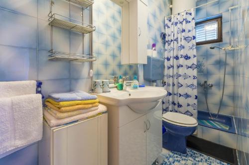 a blue and white bathroom with a sink and a toilet at Apartments Dragica in Dramalj