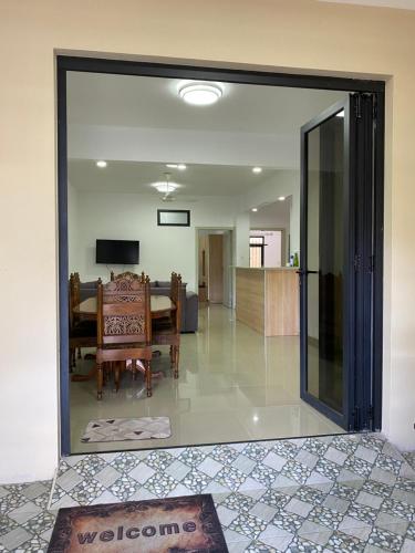 ein Wohnzimmer mit einer Glastür, die zu einem Esszimmer führt in der Unterkunft Residence La Colombe in Grand Baie