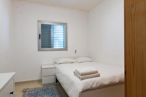 Habitación blanca con cama y ventana en O&O Group - Stylish & Cozy Seaview Vacation APT, en Bat Yam