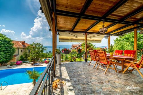 un patio con mesa y sillas junto a una piscina en Villa Lake View, en Ohrid