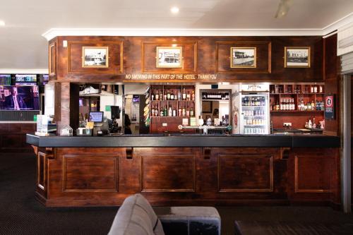 a bar with wooden cabinets and a counter with alcohol at Family Hotel in Bathurst