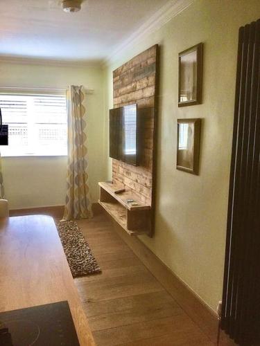a living room with a fireplace and a television on the wall at HENWICK HOUSE Beautiful flat,Private parking, short walk to town in Ludlow