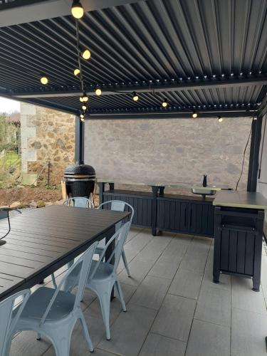 d'une terrasse avec une table et des chaises sous un auvent. dans l'établissement Barn Long House with Private pool, à Chassenon