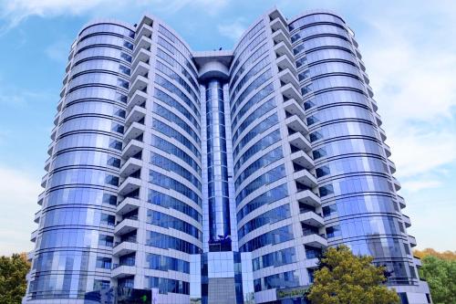 a tall blue building with trees in front of it at Butterfly Residence in Manama