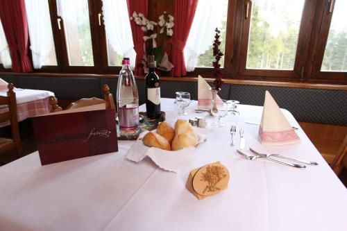 a table with a bottle of wine and bread on it at GH Hotel Fratazza in San Martino di Castrozza