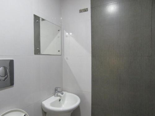 a bathroom with a sink and a toilet and a mirror at Hotel Reegate Inn in Cochin