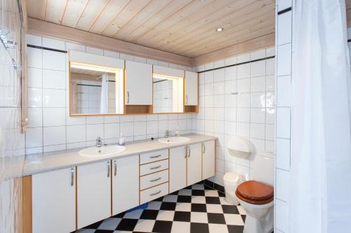 a bathroom with two sinks and a checkered floor at Topcamp Bie - Grimstad in Grimstad