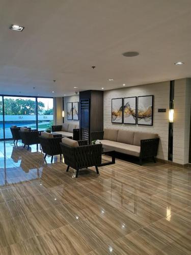 a living room with a couch and tables and chairs at Great View 1 BR Condo in Makati near Trident Tower in Manila