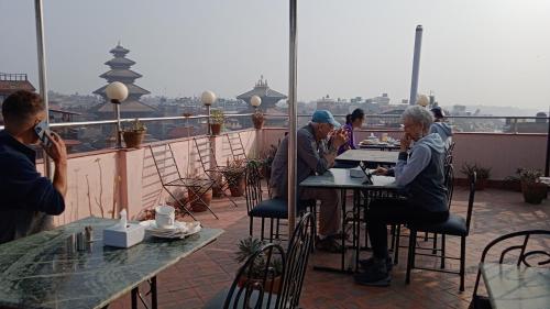 a group of people sitting at a table on a balcony at HOTEL RUPAKOT AND ROOFTOP RESTAURANT in Bhaktapur