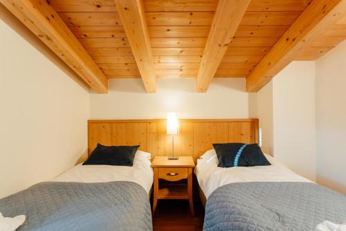 two twin beds in a room with wooden ceilings at Apartment Alexander by MoniCare in Seefeld in Tirol