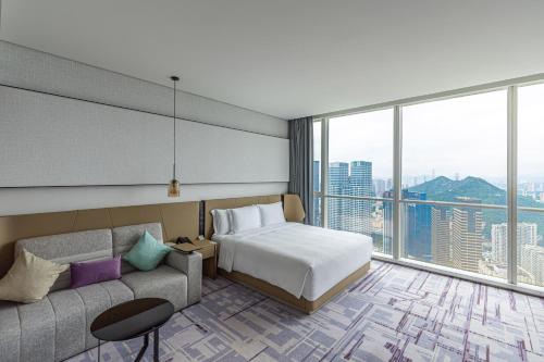 une chambre d'hôtel avec un lit et un canapé dans l'établissement Crowne Plaza Dalian Xinghai, an IHG Hotel, à Dalian