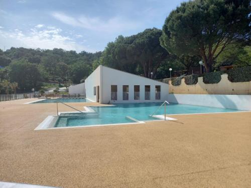a large swimming pool in front of a white building at Mobil home yves et magali in La Garde-Freinet