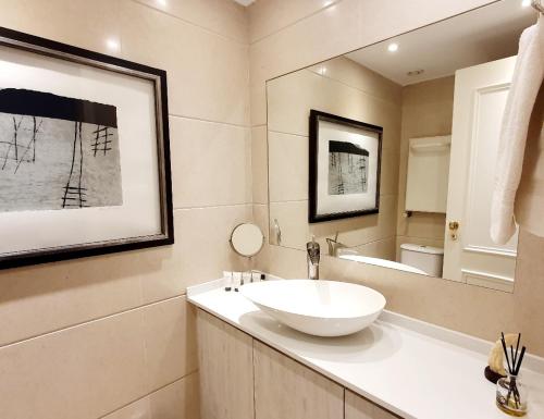 W łazience znajduje się biała umywalka i lustro. w obiekcie River View & Close to the Beach - Quarto em Almada w mieście Almada