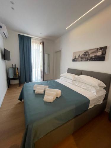 um quarto com uma cama grande e toalhas em Civicocento Charming Rooms em Catânia