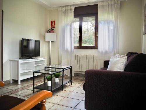 Finca La Cuesta في كانغاس دي أونيس: غرفة معيشة مع أريكة وتلفزيون