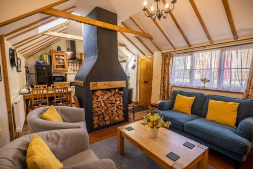 a living room with a fireplace and a blue couch at All Seasons Cottage Breaks in Saxmundham