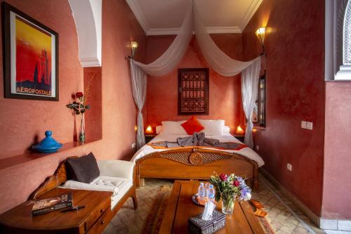 a bedroom with a bed and a chair and a table at Dar Sohane in Marrakesh