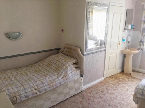 a bedroom with a bed and a window and a sink at Blythewood Guest House in Coleshill