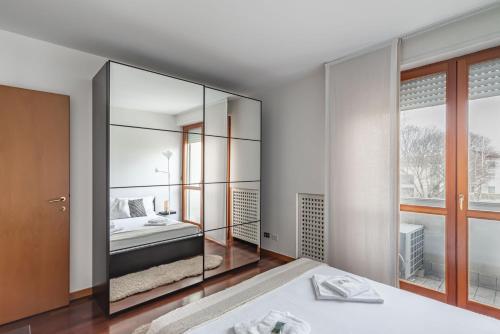een slaapkamer met een bed en een grote spiegel bij Padova Palestro Pastel Apartment in Padua