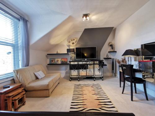 a living room with a couch and a tv at Victoriana Apartment, Central - Boutique in Stratford-upon-Avon