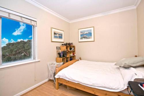 a bedroom with a bed and a window at Spacious beach apartment, great sea views in Perth