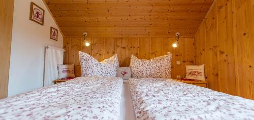 a bedroom with a large bed with wooden walls at Das Jagdhaus Bad Aussee in Bad Aussee
