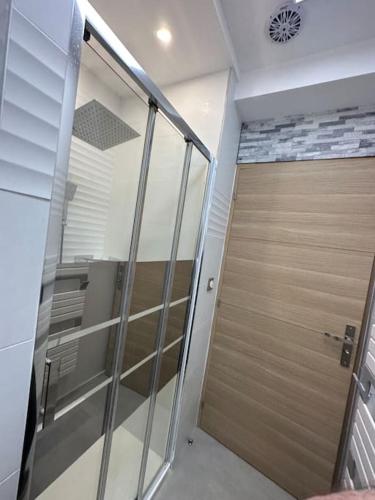 Cette chambre dispose d'une porte en verre. dans l'établissement Magnifique T2 Meyzieu neuf charme et élégance, à Meyzieu