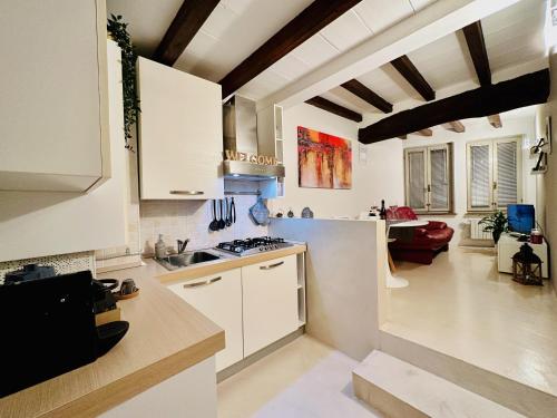 una cucina con armadi bianchi e un soggiorno di New Street House a Parma