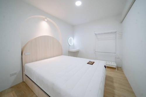 a white bedroom with a white bed and a window at Dai su ki House in Chiang Rai