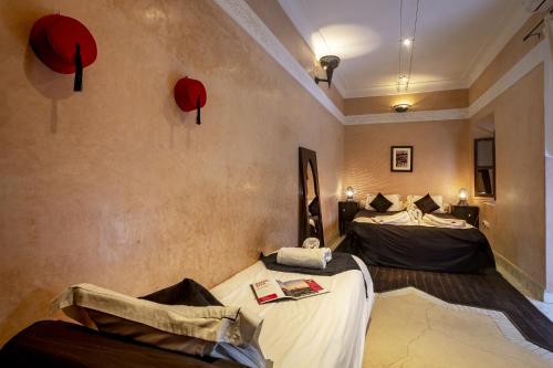 a room with two beds and red lamps on the wall at Dar Sohane in Marrakesh