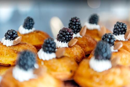 a bunch of donuts with blackberries and whipped cream at Savoia Hotel Rimini in Rimini