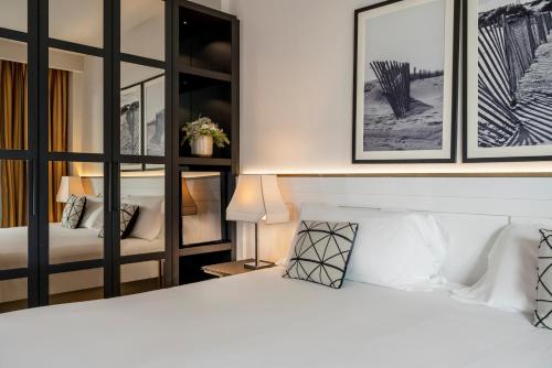 a bedroom with two beds and two framed pictures on the wall at Savoia Hotel Rimini in Rimini