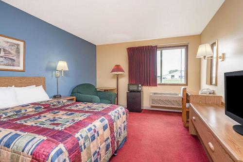 una camera d'albergo con letto e TV di Days Inn by Wyndham West-Eau Claire a Eau Claire