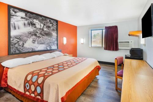 a hotel room with a bed and a television at Super 8 by Wyndham Waynesburg in Waynesburg