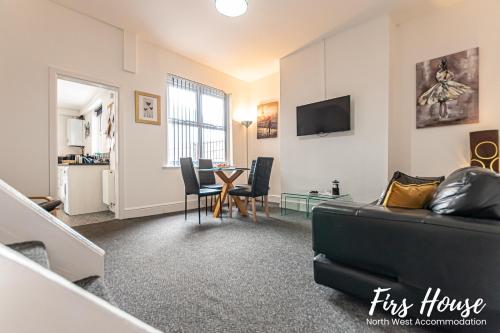 a living room with a couch and a table at Firs Serviced Accommodation in Leigh