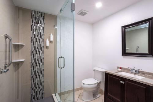 a bathroom with a toilet and a glass shower at Travelodge by Wyndham Lakeland in Lakeland