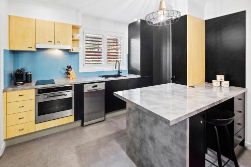 a kitchen with a sink and a counter top at Ocean View Apartment - Aqualuna Coffs Harbour in Sapphire Beach