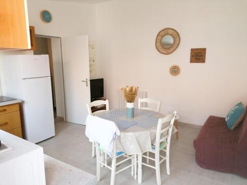 une cuisine et une salle à manger avec une table et des chaises dans l'établissement Maison de vacances entre plage et port, à La Chaume