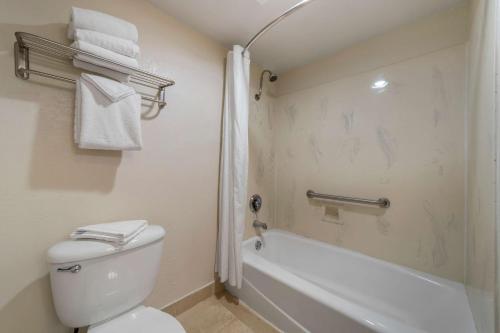 a bathroom with a toilet and a tub and a shower at Best Western Plus Northwoods Inn in Crescent City