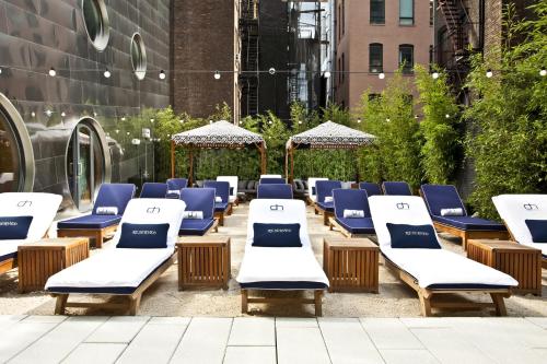 a row of lounge chairs and umbrellas on a patio at Dream Downtown in New York
