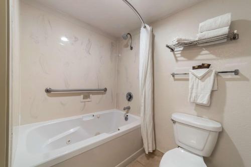 a bathroom with a tub and a toilet and a sink at Best Western Plus Northwoods Inn in Crescent City