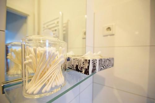 a glass jar filled with toothbrushes on top of a counter at Air Apartments 10 in Bremen